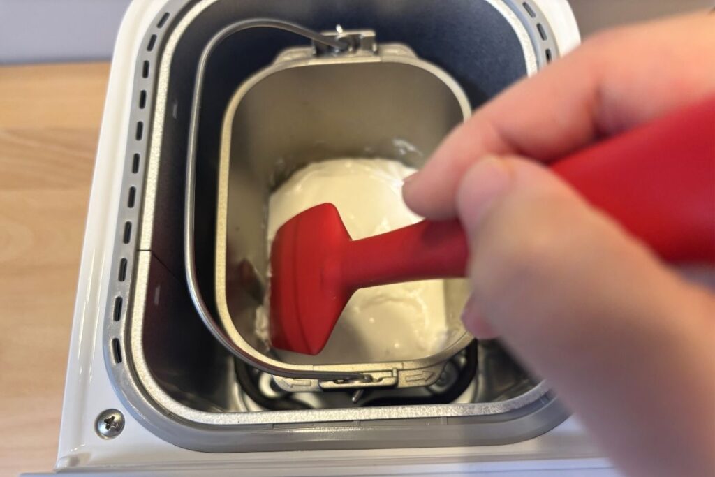 米粉パン作りでパンケースの周りについた粉を落としている様子